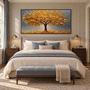 Wide yellow-canopy painting above a beige bed with blue-gray bedding and a foot bench.