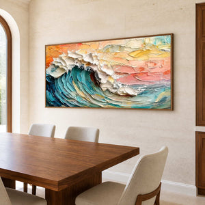 Wood framed sunset wave artwork above a wooden dining table against pale stone.