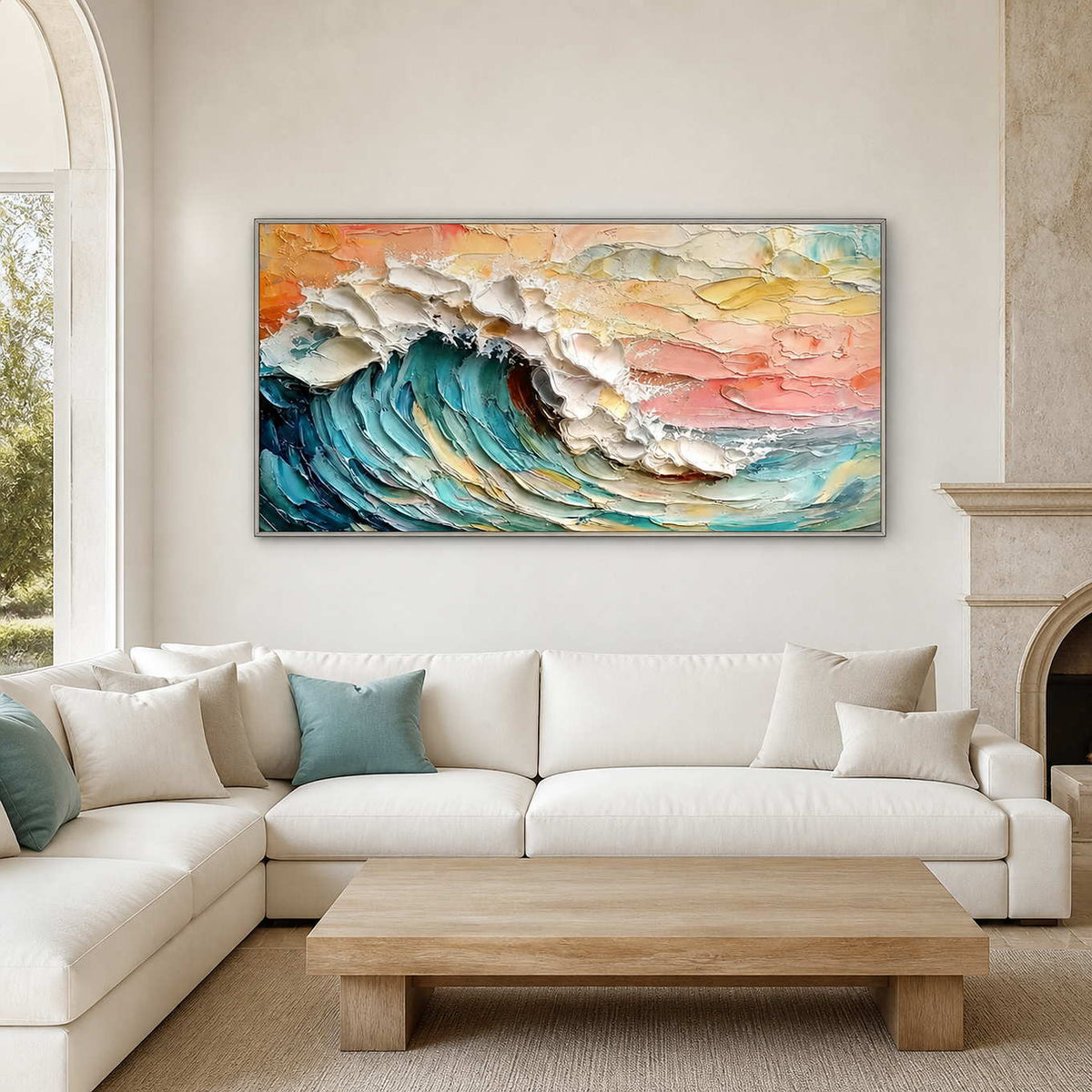 Silver framed coastal wave painting above a cream sectional with pale blue cushions.