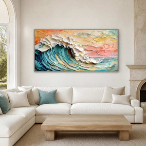 Silver framed coastal wave painting above a cream sectional with pale blue cushions.