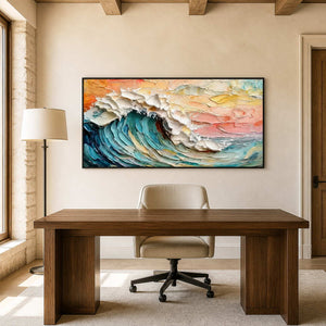 Black framed turquoise wave painting behind a simple wooden desk in a sunlit study.
