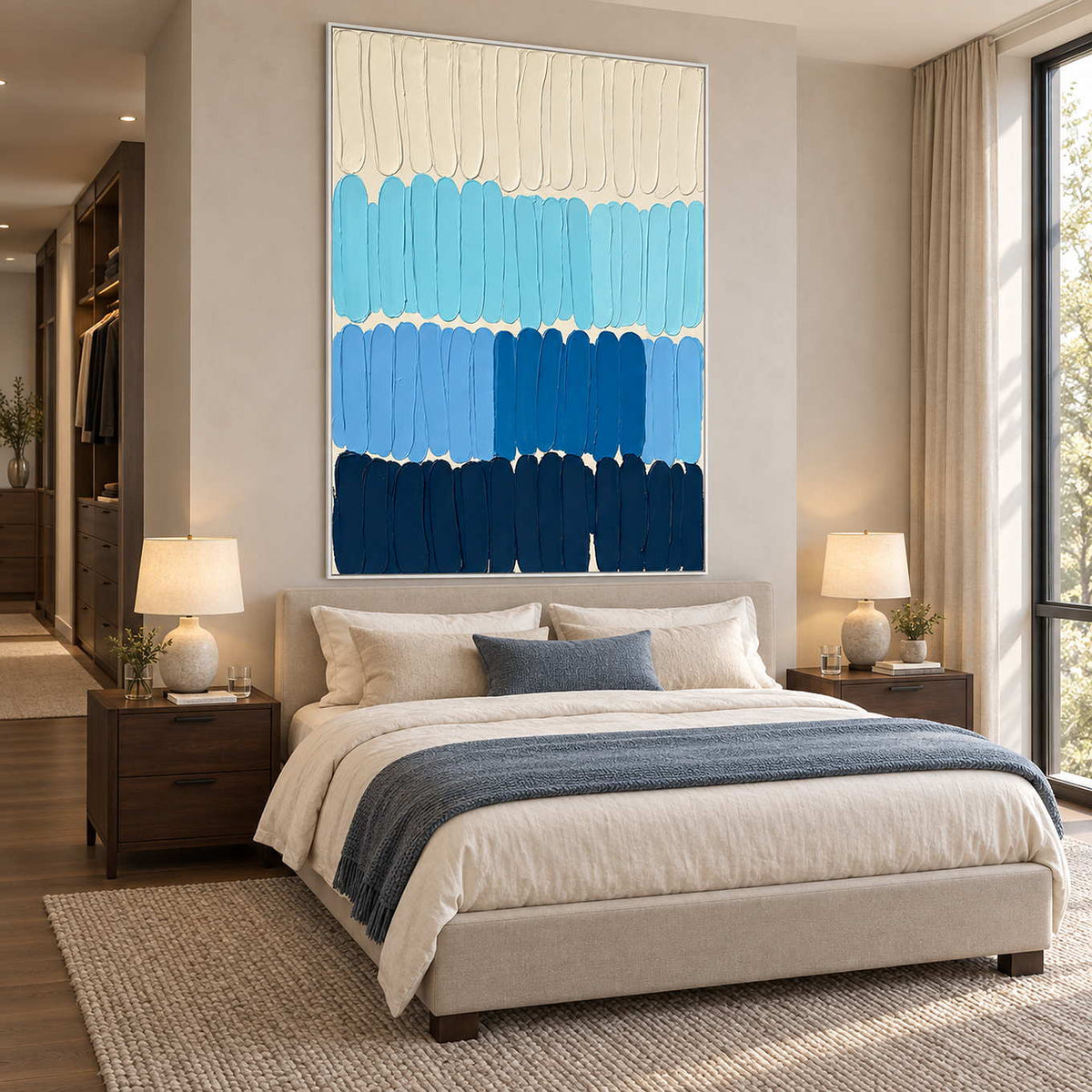 The Sea's Rhythm in a white frame above a neutral bed with a blue-gray throw and bedside lamps.
