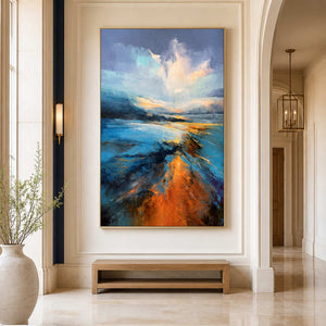 Gold framed blue shoreline artwork above a low wooden bench in a bright hallway.
