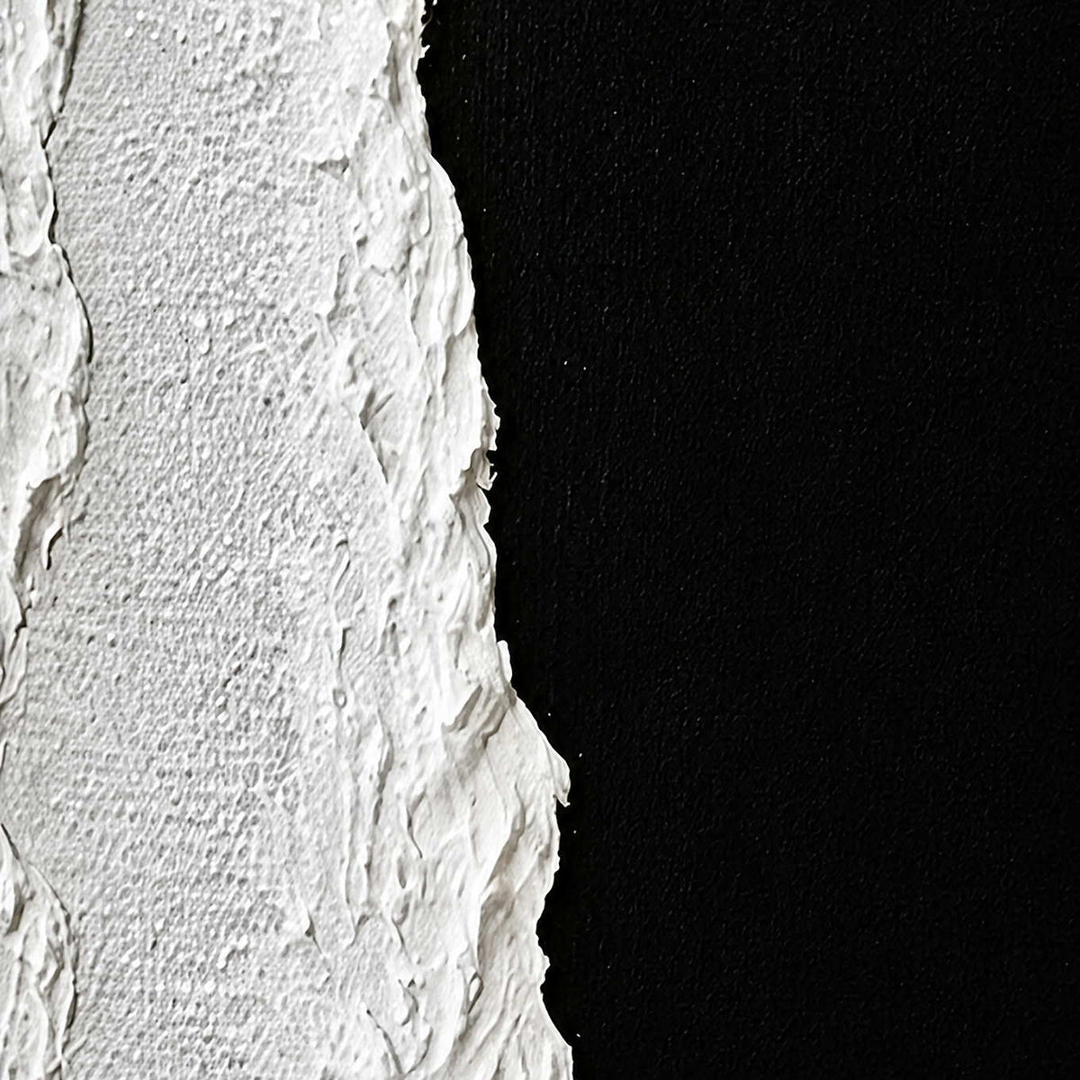 Close view of white raised seams and woven texture beside a black painted surface.