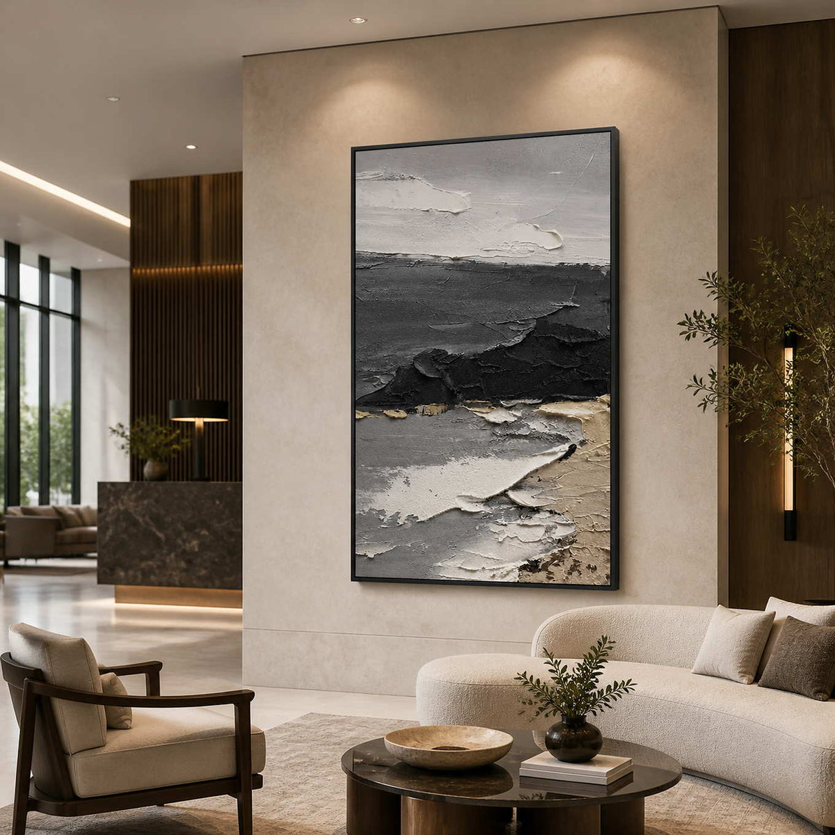 Black framed coastal abstract painting beside cream seating in a hotel lobby.