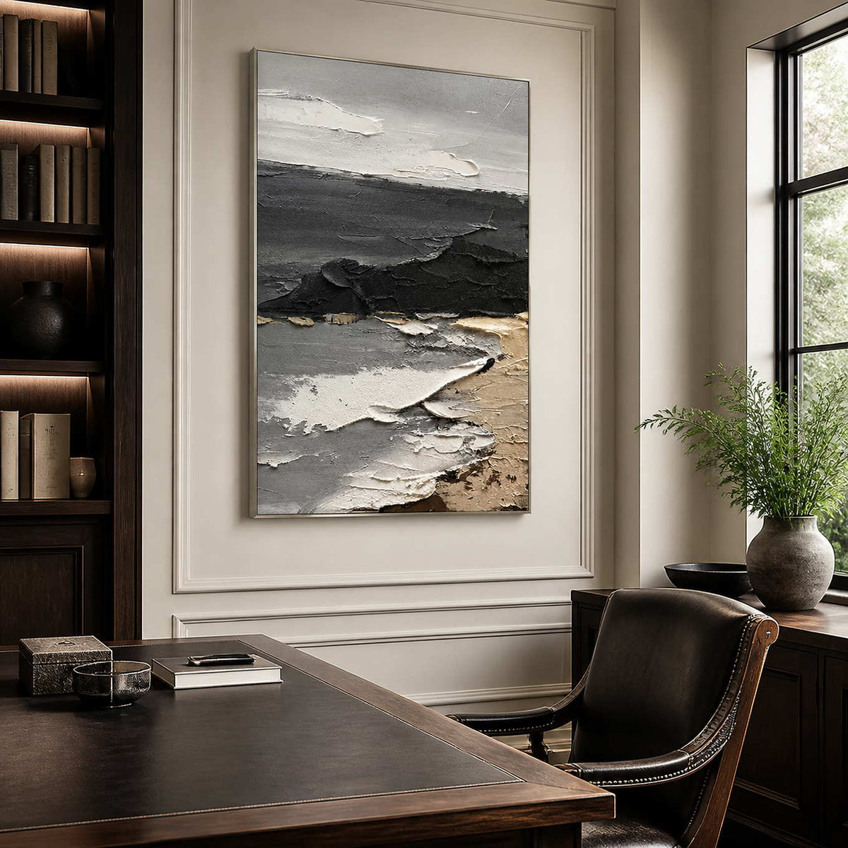 Silver framed gray abstract painting behind a leather chair in a dark wooden study.