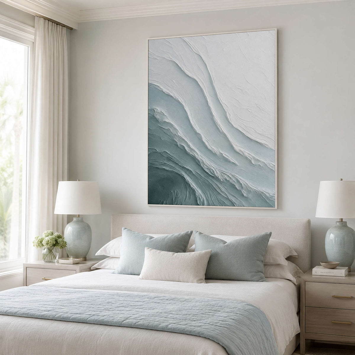 Textured ocean wall art above a soft blue bedroom