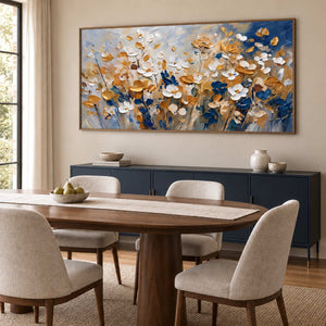 The Time to Bloom in a wood frame above a navy sideboard beside an oval wood dining table and cream chairs.