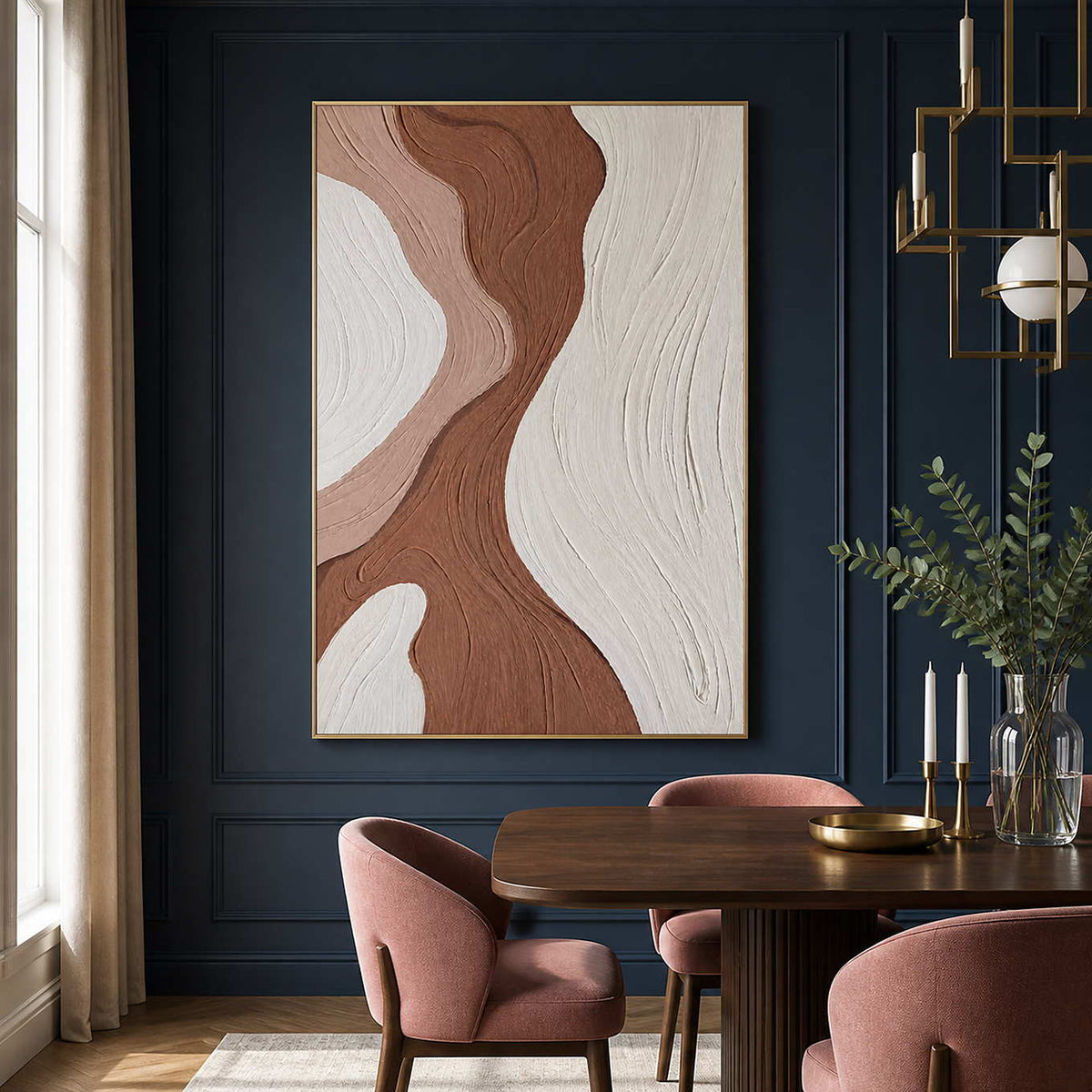 Gold framed abstract artwork beside a dark dining table and blush chairs.