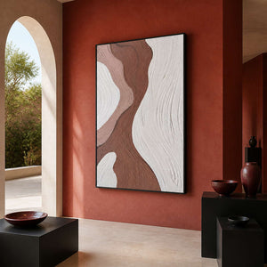 Black framed abstract artwork displayed beneath a terracotta arch with sculptural vases.
