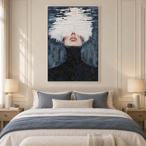 White-obscured portrait over a cream bed with blue-gray throw and pillows.