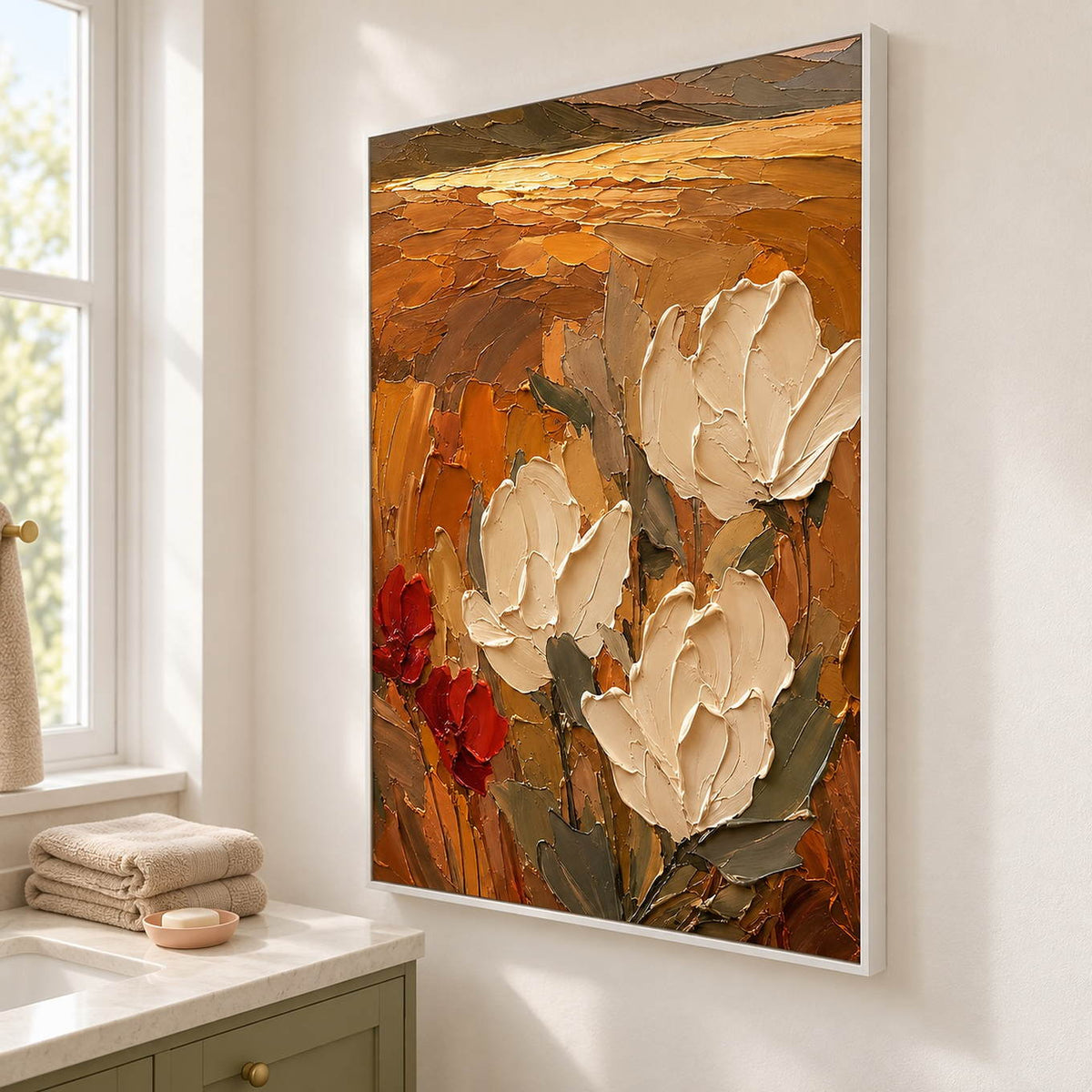 Textured cream flowers painting against an amber and rust background in a white frame beside a bathroom vanity.
