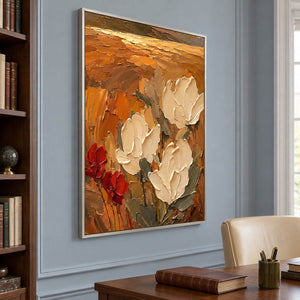 Textured cream flowers painting against an amber and rust background in a silver frame in a home office.