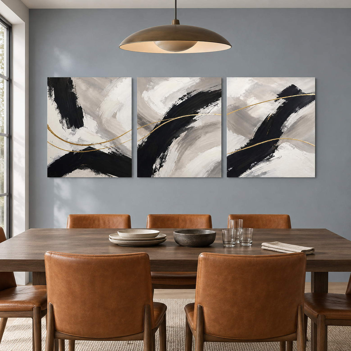 Three vertical abstract panels with black gestures, ivory fields, and gold lines, displayed in a dining room without outer frames.
