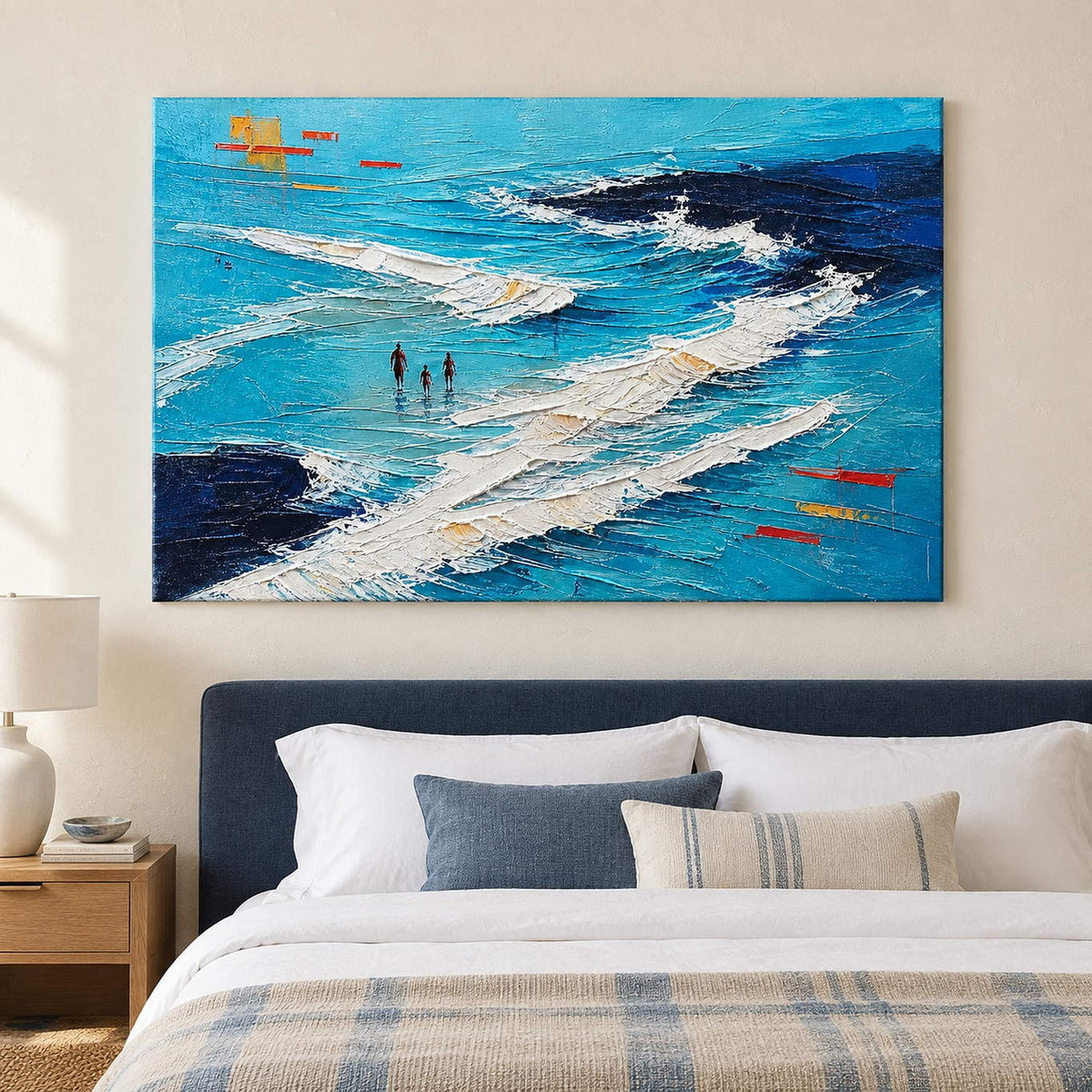 Turquoise coastal painting with three figures among white breaking waves without an outer frame in a bedroom.