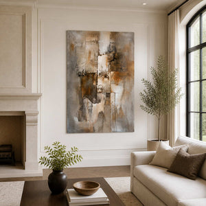 Frameless brown and taupe abstract artwork beside a stone fireplace and neutral living room sofa.