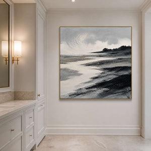 Square black and ivory seascape wall art in a bathroom with a gold frame.