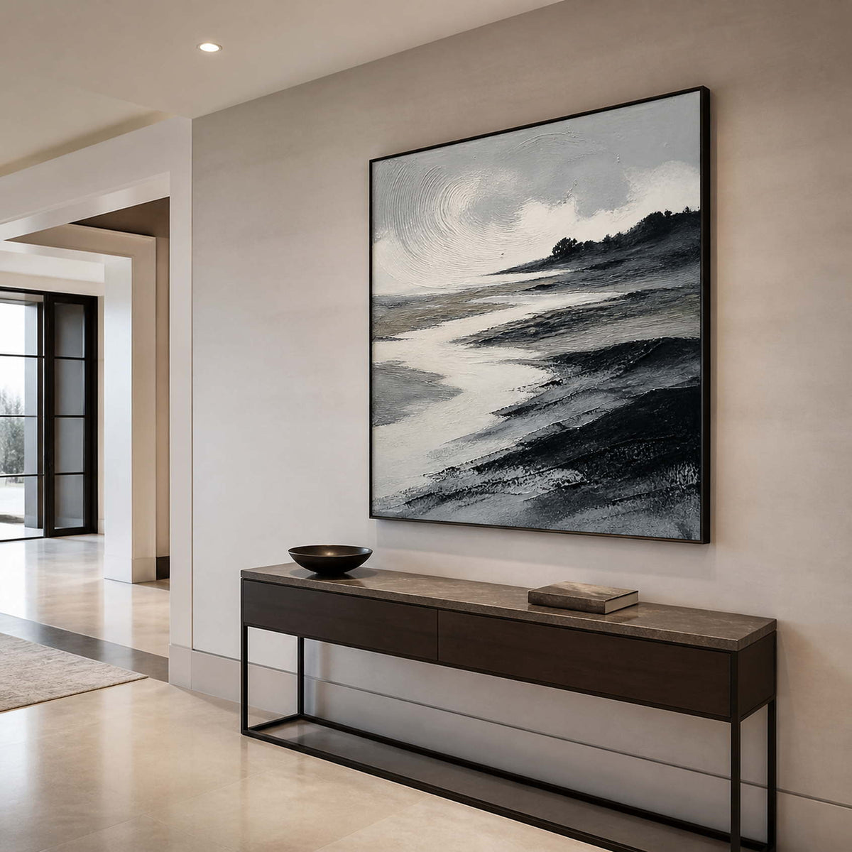 Textured ocean landscape wall art in an elegant entryway with a black frame.