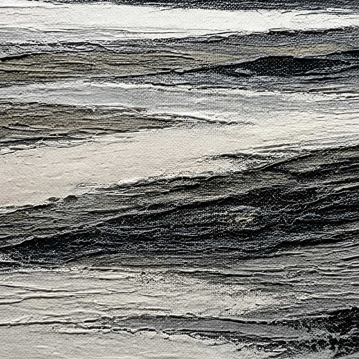 Close-up of layered black, ivory, and gray shoreline texture.