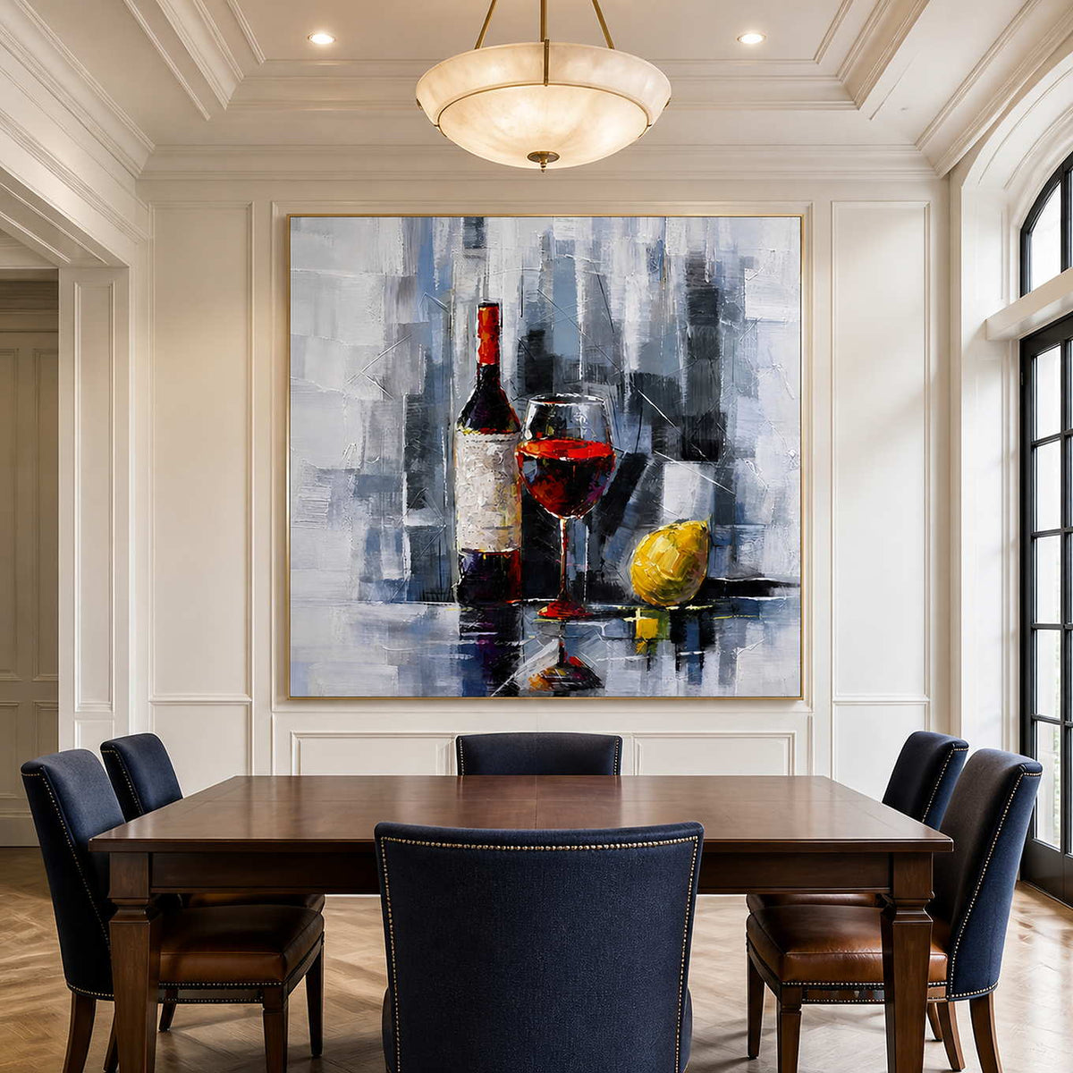Gold framed wine and lemon painting above a banquet table with navy chairs.