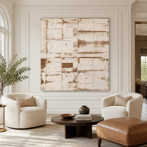 Frameless cream abstract above two rounded ivory chairs and a low oval wooden table.