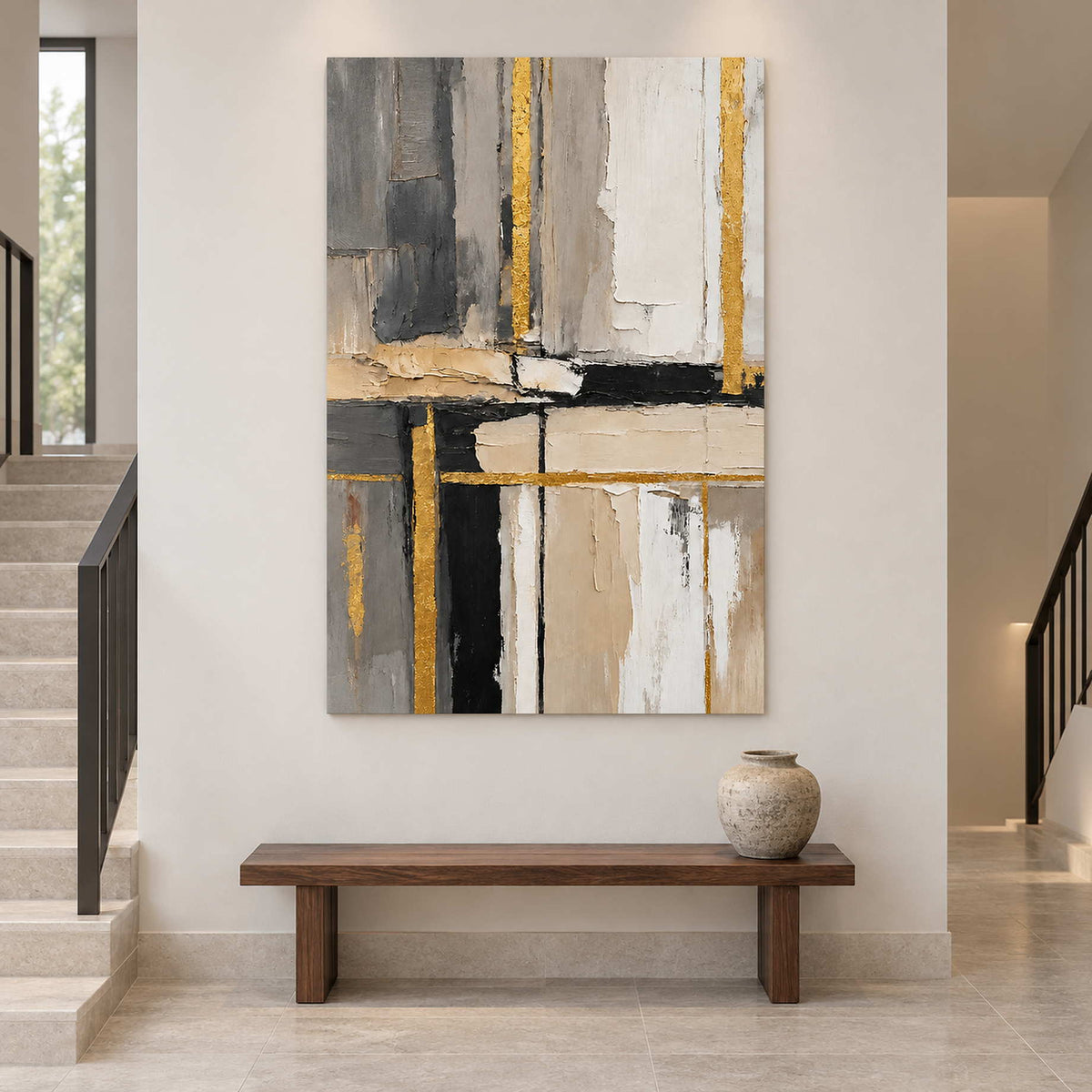 Gray, ivory, and black artwork above a wood bench beside a staircase.