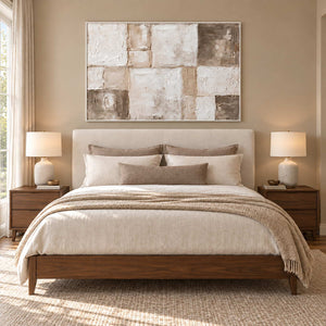 Time in Soft Focus in a white frame above a neutral bed with warm beige layers and wood bedside tables.