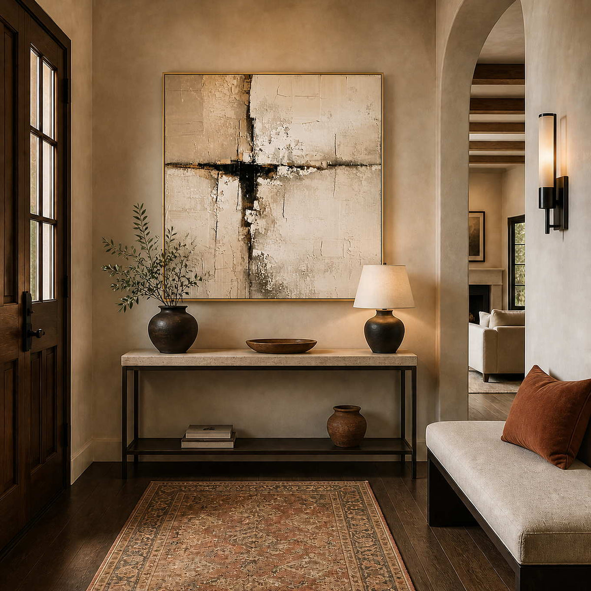 Gold framed square abstract artwork over a stone console beside an arched entryway opening.
