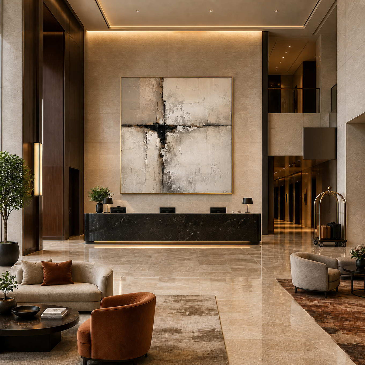 Gold framed abstract artwork above a hotel reception desk near elevators and a luggage trolley.