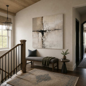 Frameless neutral abstract artwork above a cushioned bench on a bright residential stair landing.