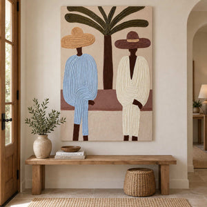 Figures beneath a palm displayed above a wood bench with a ceramic vase and woven basket.