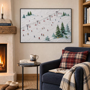 Snowy ski slope painting with red chairlifts, colorful skiers, and evergreen trees in a black frame in a seating area beside a fireplace.