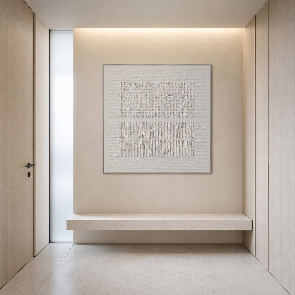 Square ivory relief wall art in a pale stone entryway.
