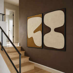 Earth-tone abstract panels viewed beside a deep brown residential staircase.