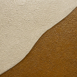 Close-up of granular ivory and ochre painted surface texture.