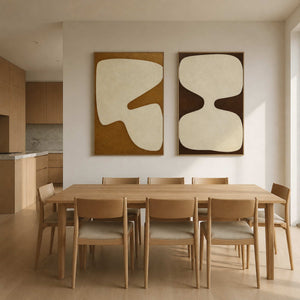 Earth-tone abstract diptych displayed above a light wood dining room.