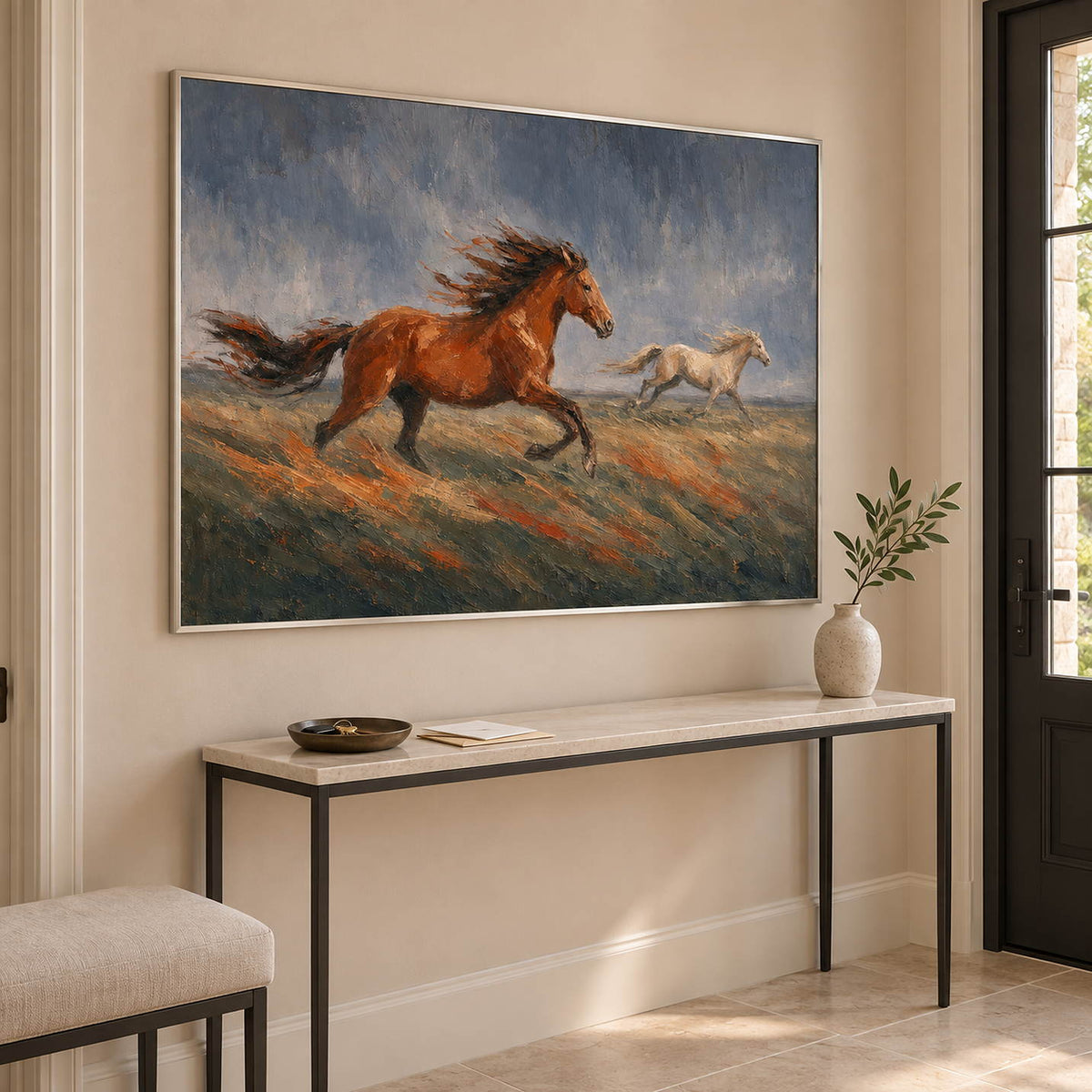 Hand-painted scene of chestnut and pale horses running across open ground, displayed in an entrance hall in a silver frame.