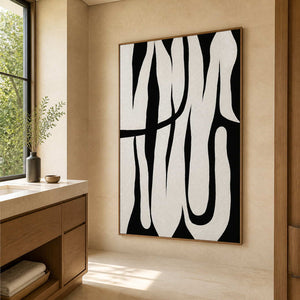 Wood framed black and white curved artwork beside a stone vanity and wooden bathroom cabinetry.