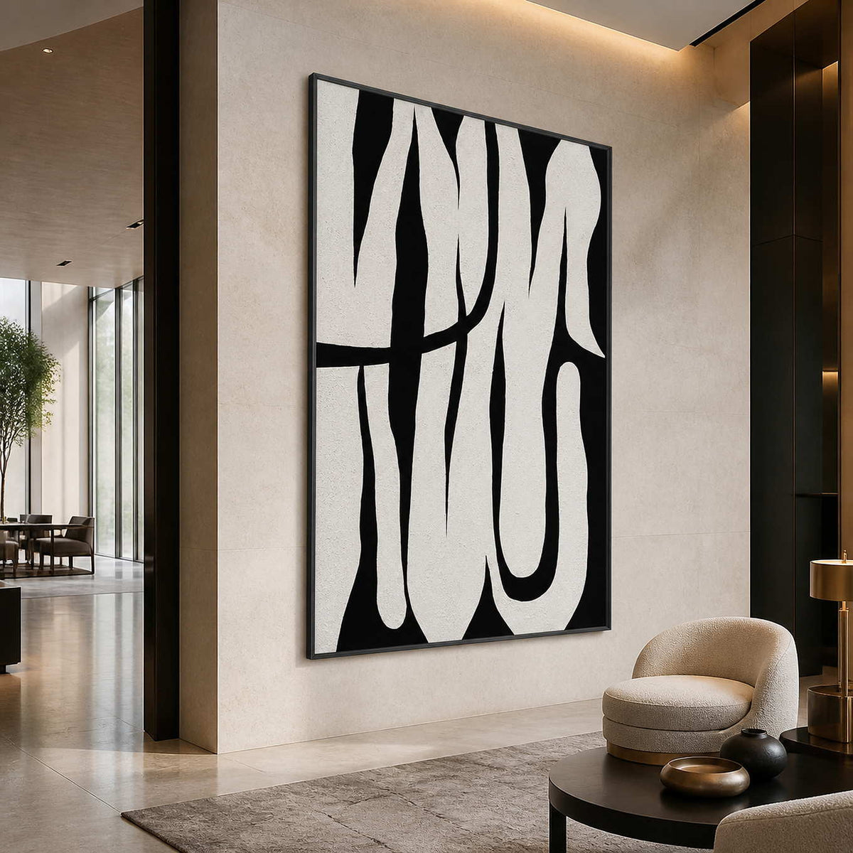 Black framed monochrome abstract artwork beside rounded lounge seating in a spacious hotel lobby.