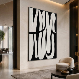 Black framed monochrome abstract artwork beside rounded lounge seating in a spacious hotel lobby.
