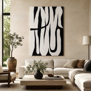 Frameless black and white curved abstract artwork above a cream sectional sofa near leafy plants.