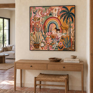 Under the Rainbow in a black frame above a light wood hallway console with books and a woven stool.