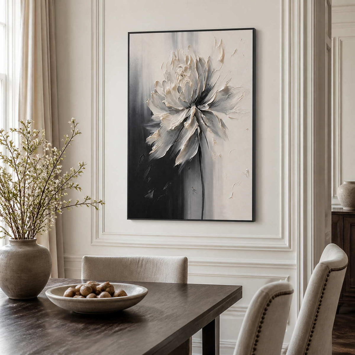 Black framed ivory flower artwork above a dark wood dining table.