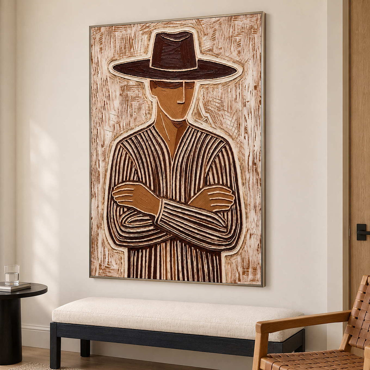 Tall folded-arm portrait over a cream bench beside a woven wooden chair.