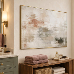 Neutral abstract painting with ivory, taupe, clay, and olive layered marks in a gold frame beside a bathroom vanity.