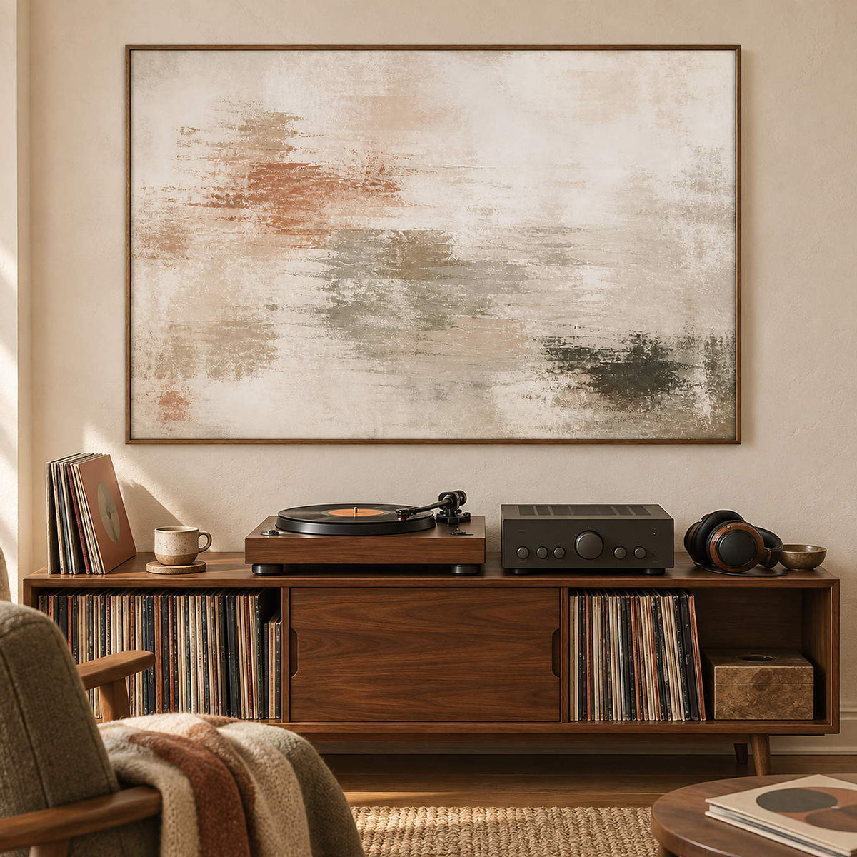 Neutral abstract painting with ivory, taupe, clay, and olive layered marks in a brown wood frame in a music listening room.