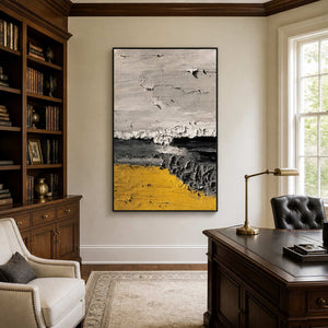 Black framed yellow abstract artwork beside wooden bookshelves and a traditional home office desk.