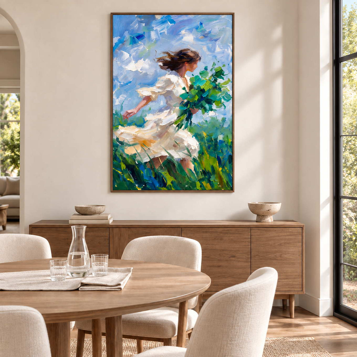 Walking into the Breeze in a wood frame above a sideboard beside a round pale wood dining table and cream chairs.
