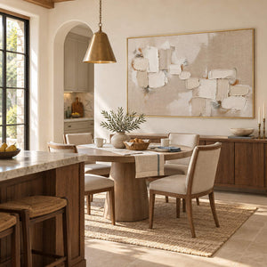 Textured abstract painting with raised ivory and taupe blocks in a gold frame in a breakfast dining area.