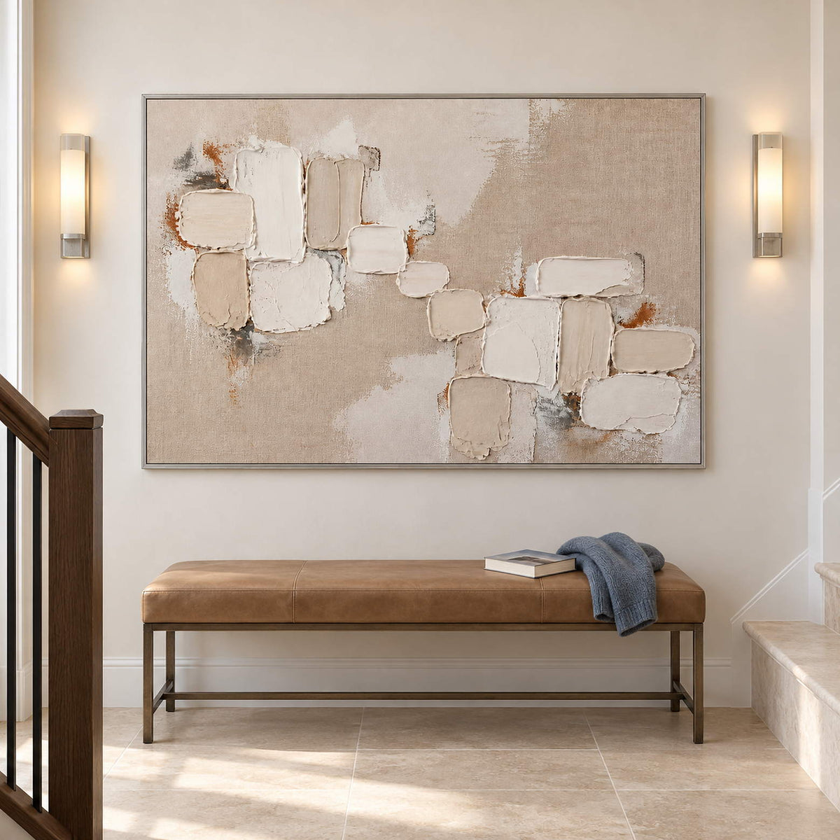 Textured abstract painting with raised ivory and taupe blocks in a silver frame on a stair landing.